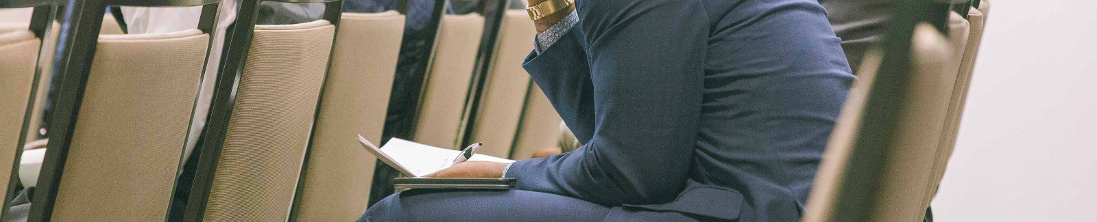 male in a suit listening intently to a financial workshop that was hosted by Meridian Financial Trust Bank